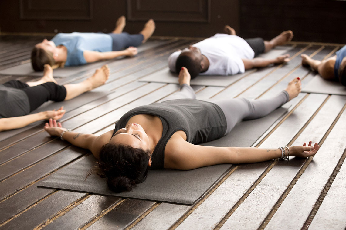 Group breathwork participants lying on yoga mats in a studio